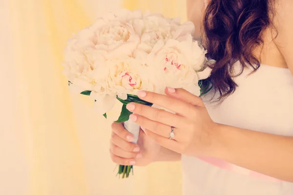 Menyasszony kezében esküvői csokor fehér pünkösdi rózsa, zár-megjelöl, a világos háttér — Stock Fotó
