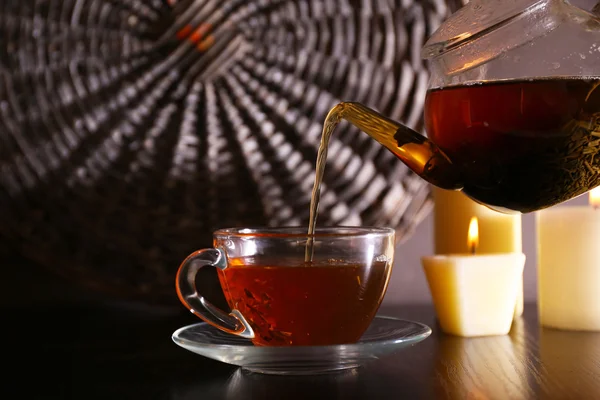 Tea pouring into glass cup on dark background — Stock Photo, Image