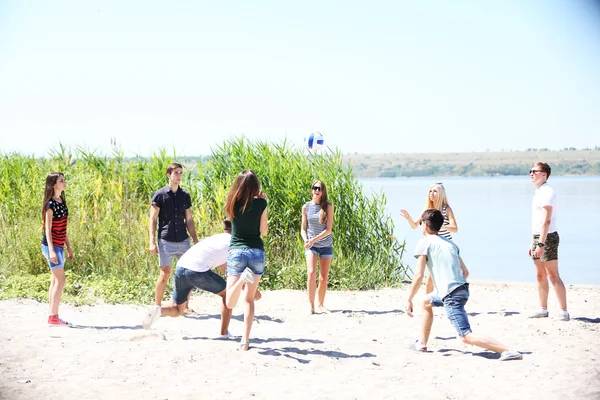 Unge mennesker som spiller volleyball på stranda – stockfoto