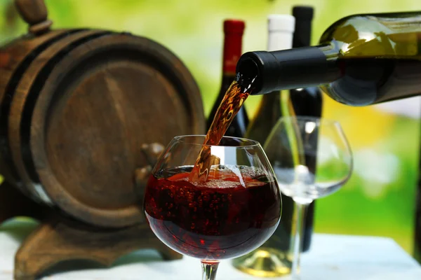 Vin rouge versé dans un verre à vin, gros plan — Photo