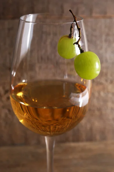 Glas wijn en rijpe druif op houten achtergrond — Stockfoto