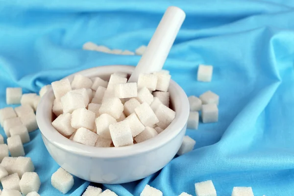 Raffinierter Zucker im Mörser auf farbigem Textilhintergrund — Stockfoto