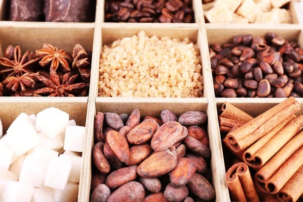 Holzkiste mit Kaffee und Kakaobohnen, Zuckerwürfeln, dunkler Schokolade, Zimt und Anis, Nahaufnahme — Stockfoto