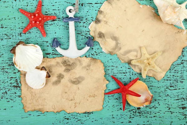 Decoración de conchas marinas, estrellas de mar y papel viejo sobre fondo de madera de color —  Fotos de Stock