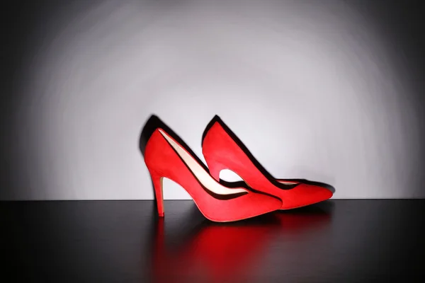 Pair of woman's red shoes on floor on light wall background — Stock Photo, Image