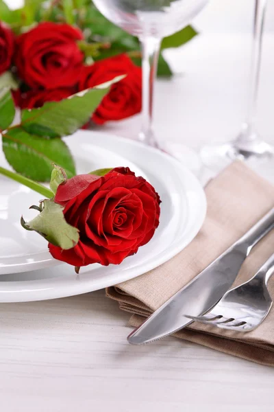 Накрытие стола с красной розой на тарелке — стоковое фото