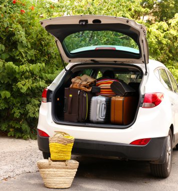 Suitcases and bags in trunk of car ready to depart for holidays clipart