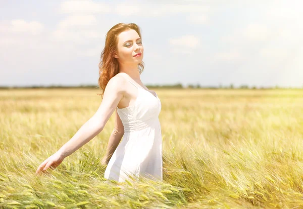 Beautiful young woman in field — Stock Photo, Image