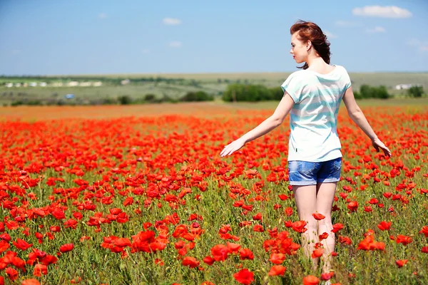 Vacker ung kvinna i vallmo blommor fält — Stockfoto
