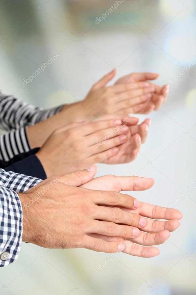 Clapping hands on bright background