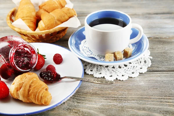 Śniadanie z herbata, dżem malinowy i świeże rogaliki na drewniane tła — Zdjęcie stockowe