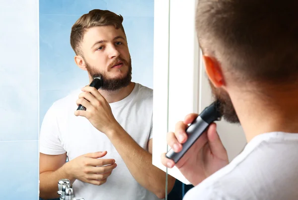 Jeune homme rasant sa barbe dans la salle de bain — Photo