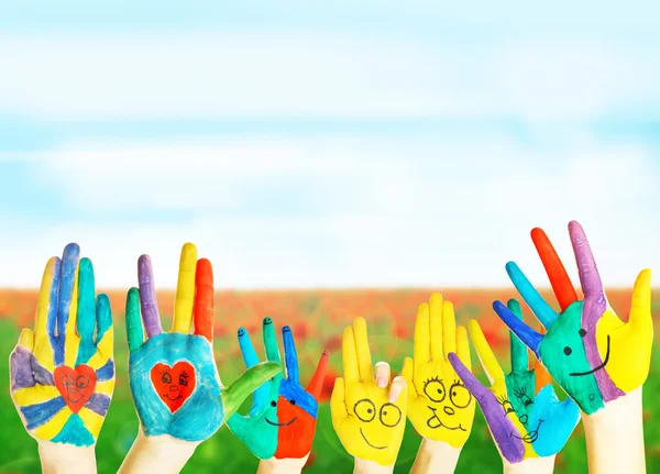 Painted hands on field background — Stock Photo, Image