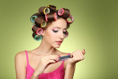 yeşil zemin üzerine saç curlers içinde güzel bir kız