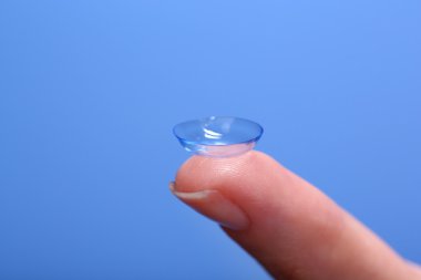 Kontakt lens mavi zemin üzerine parmak