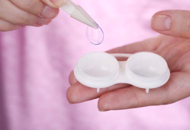 Kontakt lensler, içeren kapsayıcı tutan kadın yakın çekim