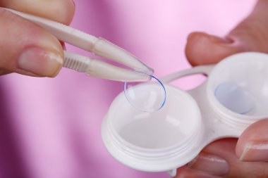 Kontakt lensler, içeren kapsayıcı tutan kadın yakın çekim