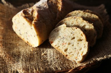Hasır sepet ahşap arka plan üzerinde çul peçeteye üzerinde beyaz ekmek dilimlenmiş