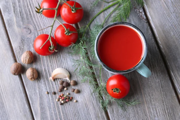Zelfgemaakte tomatensap in kleur mok, specerijen en verse tomaten op houten achtergrond — Stockfoto