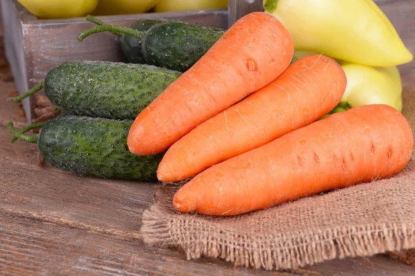 Sárga paprika, láda, asztal sárgarépa és uborka közelről — Stock Fotó