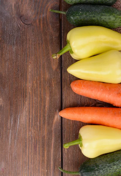 Sárga paprika, uborka és a sárgarépa, a fából készült háttér — Stock Fotó