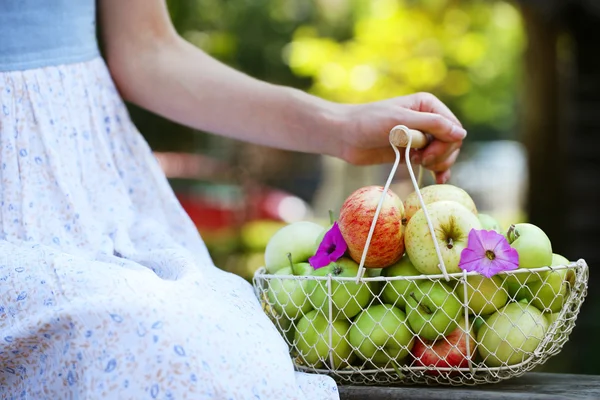 Dziewczynka gospodarstwa kosz jabłek na zewnątrz — Zdjęcie stockowe