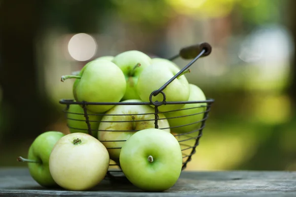 Ripe apples in basket outdoors — Stock Photo, Image