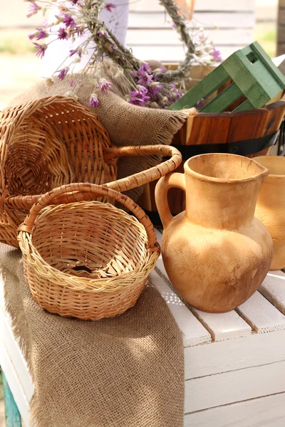 Wicker baskets and pitcher on wooden box