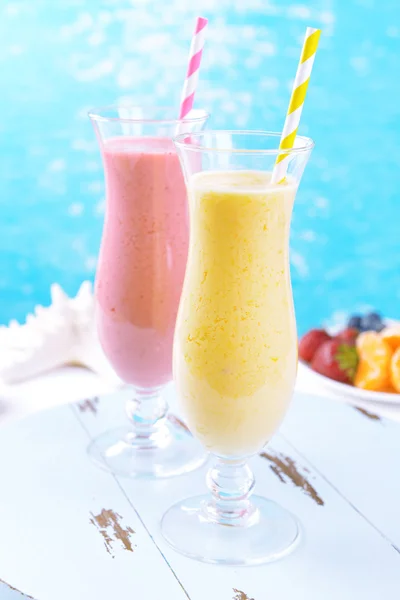 Köstliche Beerencocktails auf dem Tisch auf Wasserhintergrund — Stockfoto