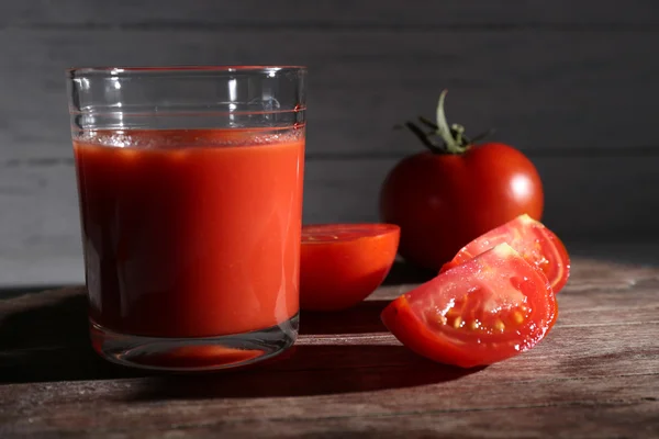 Vaso de jugo de tomate con especias y tomates frescos sobre mesa de madera. Con fondo oscuro —  Fotos de Stock