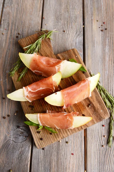 Delicious melon with prosciutto on table close-up — Stock Photo, Image