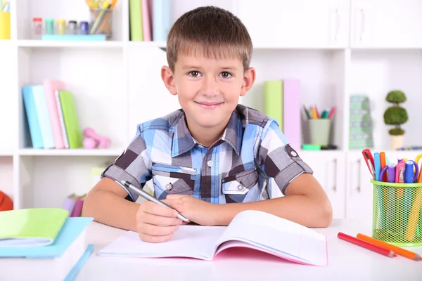 Schoolboy sitting at table in classroom — Stock Photo, Image