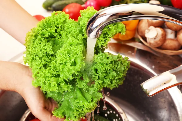 Vrouw handen wassen groenten in zinken in keuken — Stockfoto