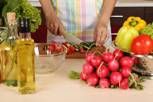 Женщина готовит овощной салат на кухне — стоковое фото