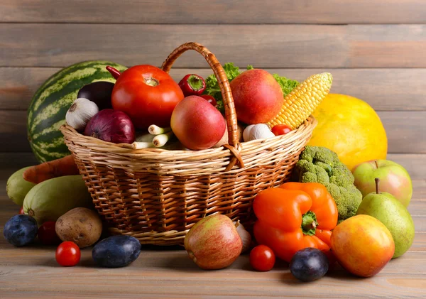 Fresh organic fruits and vegetables on wooden background — Stock Photo, Image