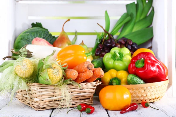 Vegetables in baskets on white wooden box background — Stock Photo, Image