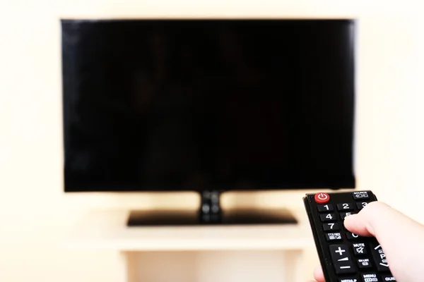 Assistir TV e usar o controle remoto — Fotografia de Stock