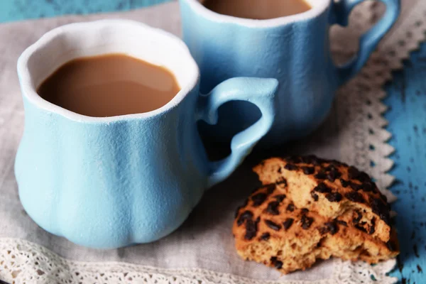 Tazze di caffè con biscotti e tovagliolo sul tavolo di legno — Foto Stock