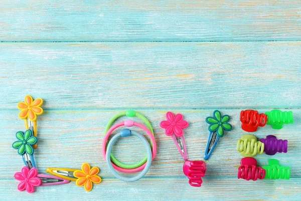 Liefde woord gevormd met kleurrijke scrunchies op houten achtergrond — Stockfoto