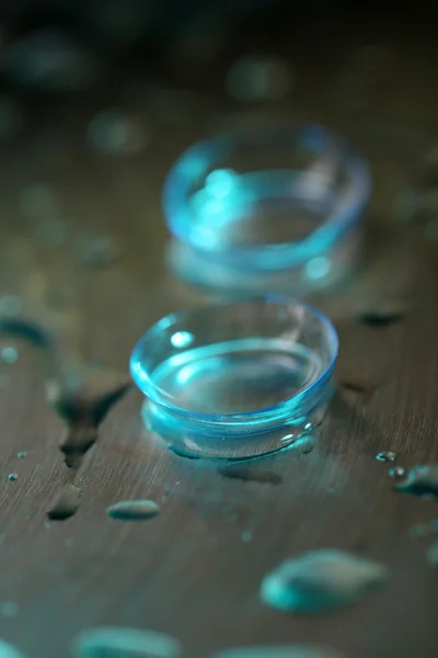 Kontaktlinser med vattendroppar på ljus bakgrund — Stockfoto