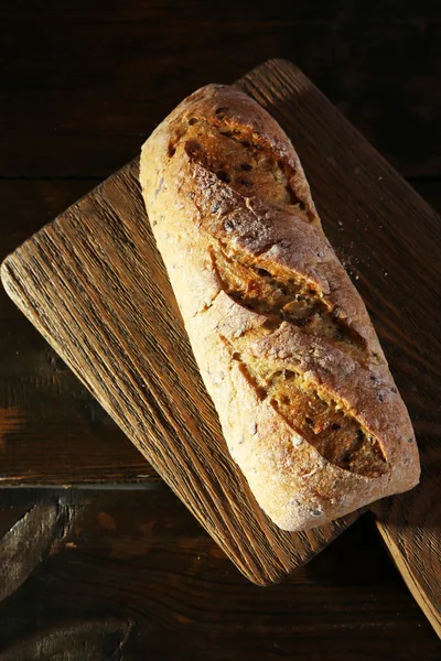 Bílý chléb na prkénko na dřevěné pozadí — Stock fotografie