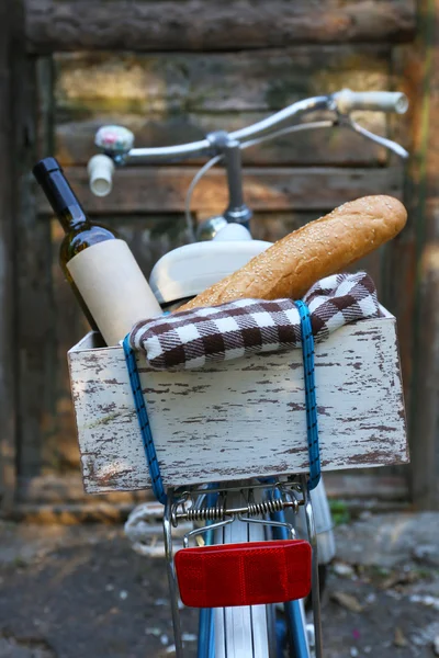 Bicicleta con picnic en caja de madera sobre fondo de puerta de madera vieja — Foto de Stock