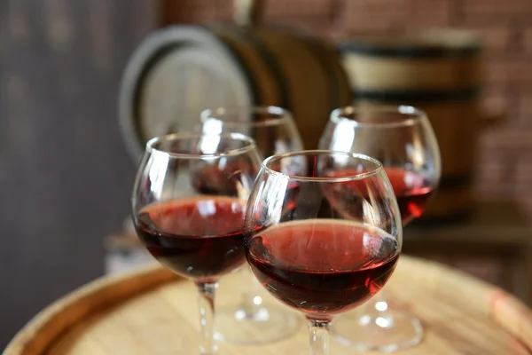 Bicchieri di vino in cantina con botti vecchie — Foto Stock