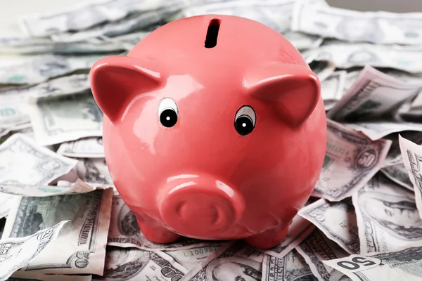 Piggy bank op geld achtergrond — Stockfoto