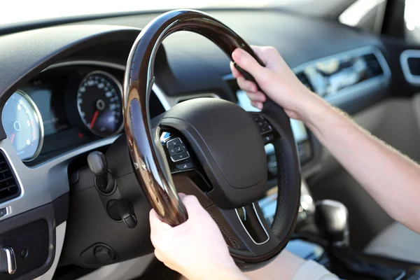Man's hands on a steering wheel Stock Picture