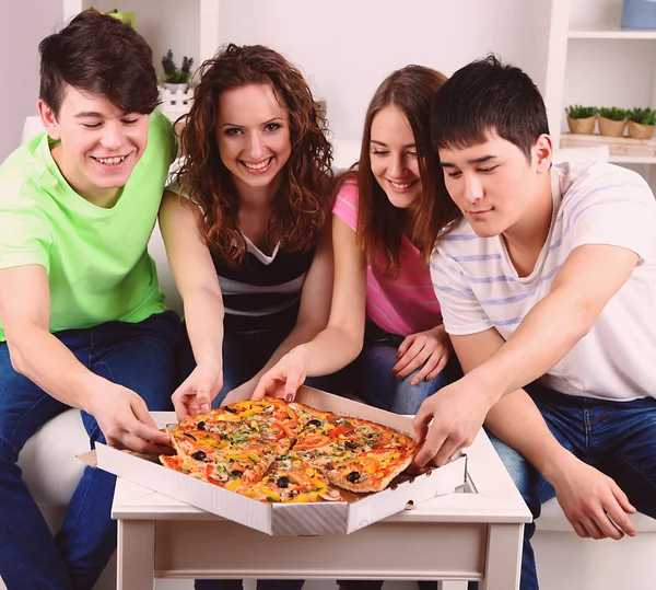Jonge vrienden eten van pizza Stockafbeelding