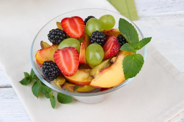 Frischer, schmackhafter Obstsalat auf Holztisch — Stockfoto