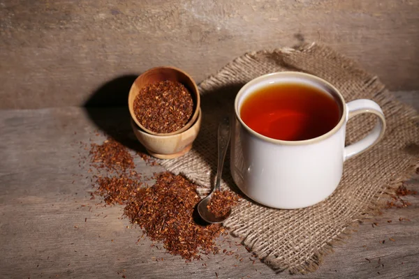 Tazza di gustoso tè rooibos, sul tavolo di legno — Foto Stock