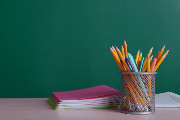 School supplies on table on board background