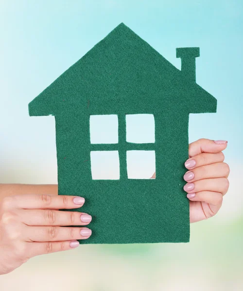 Woman hands holding paper house on bright background — Stock Photo, Image